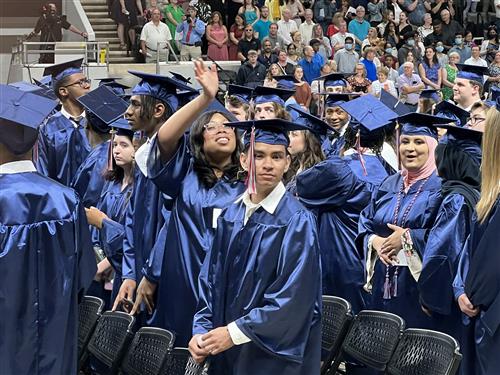 Bob Jones student in cap and gown waving into audience